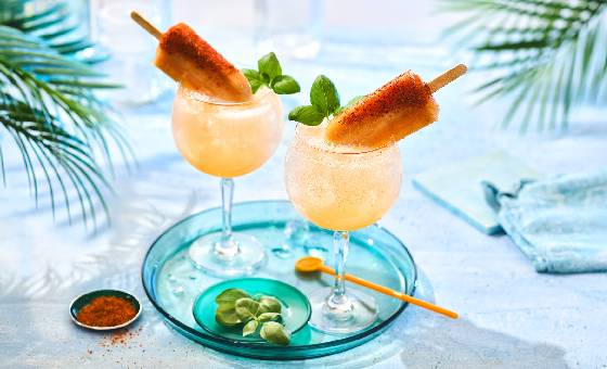 Two guava popsicle fizz cocktails on marble tabletop